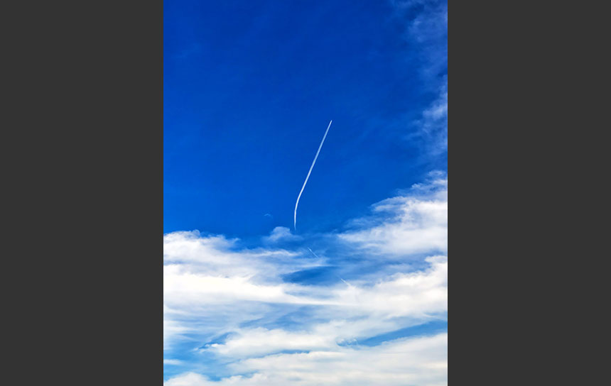 青空に弧をえがく飛行機雲